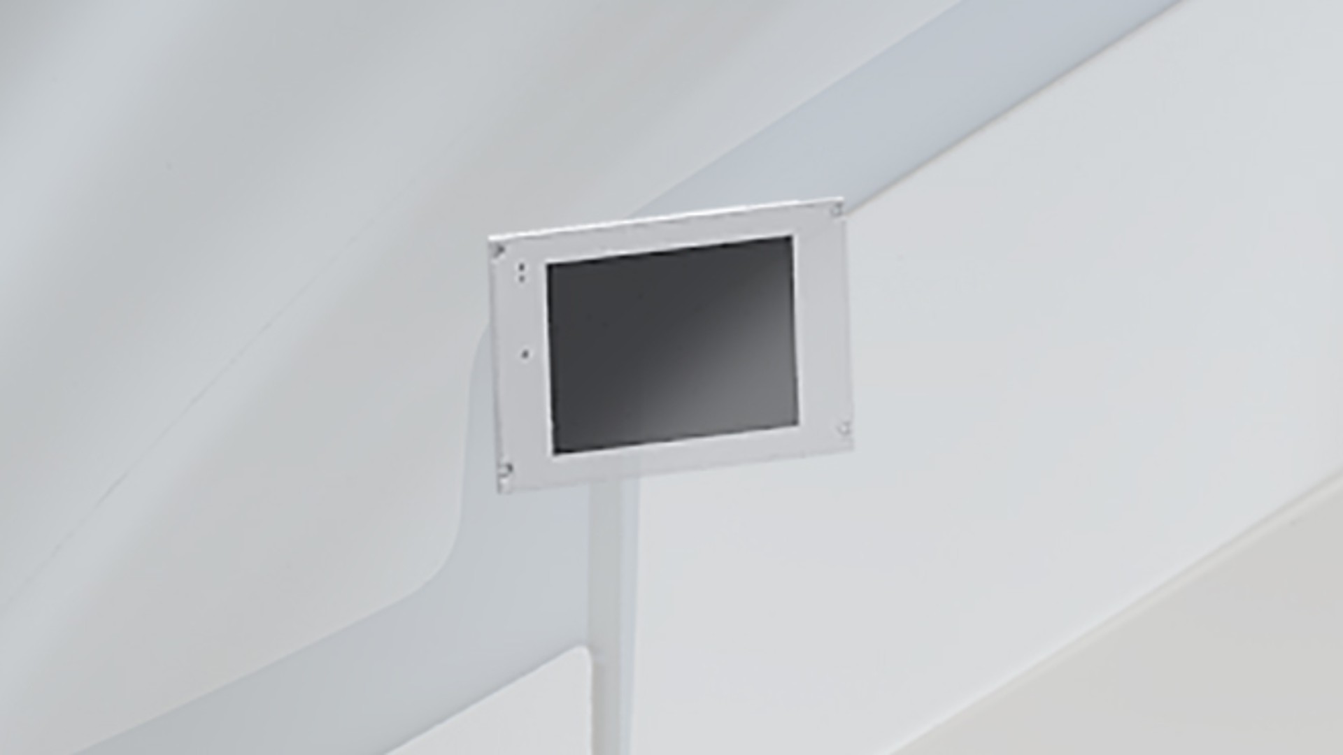 Monitor mounted on a white wall display.