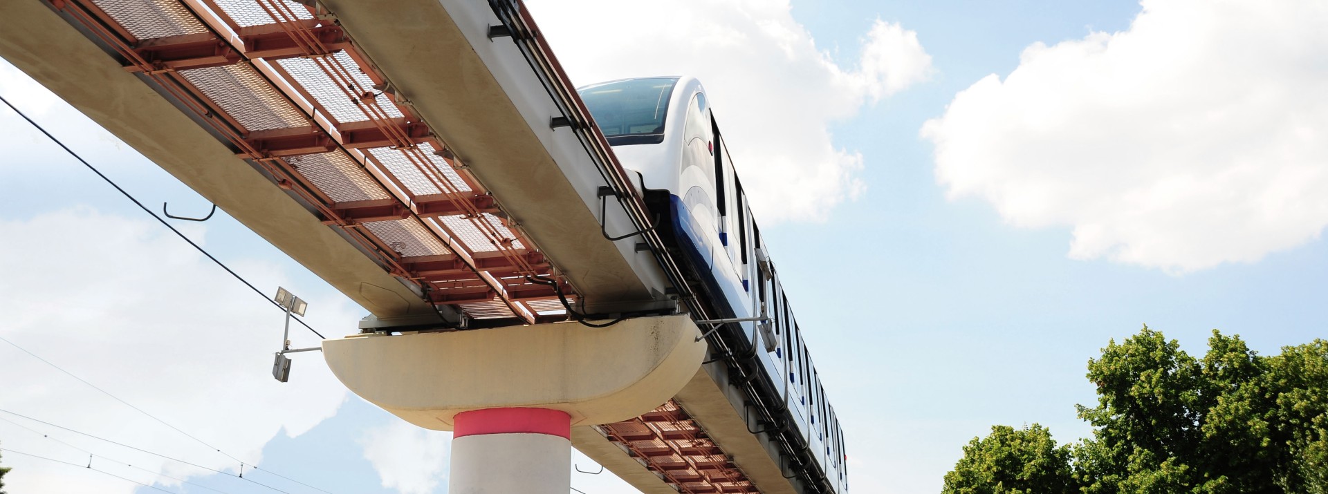 Monorail train on elevated track against blue