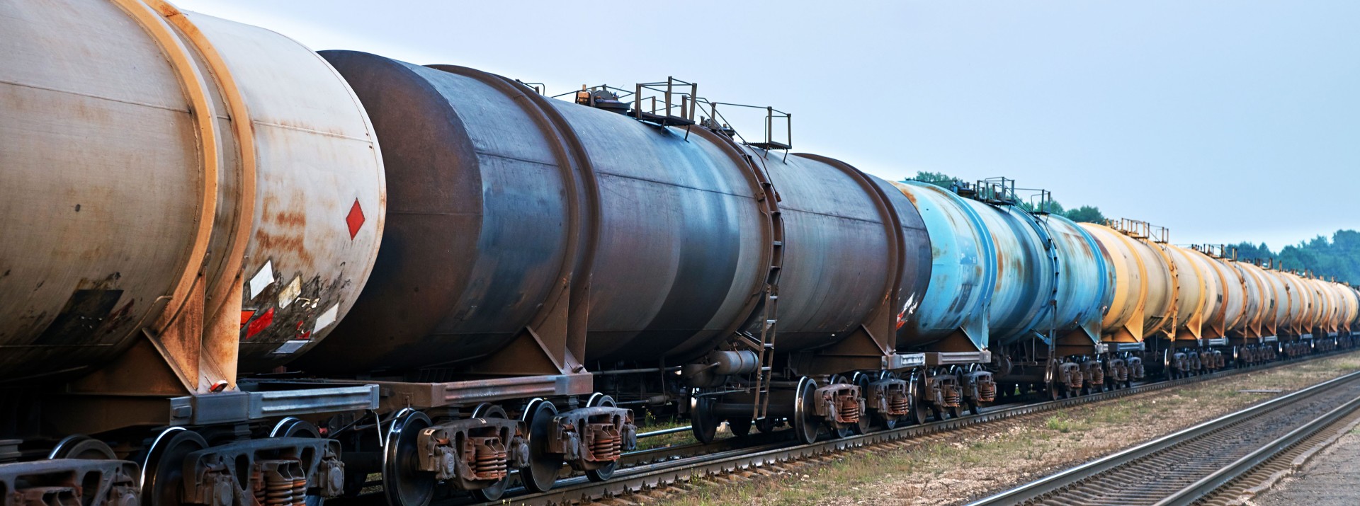 Train cars transporting various liquid materials.