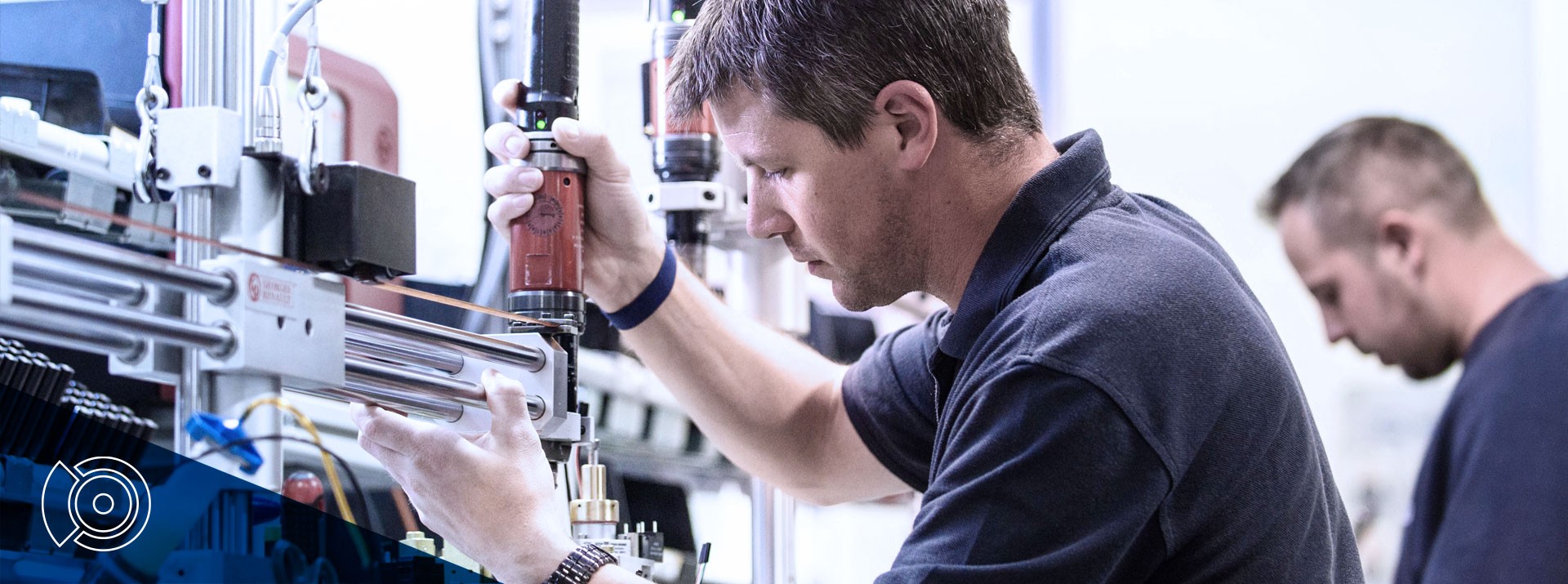 Technicians assembling equipment in a manufacturing facility.