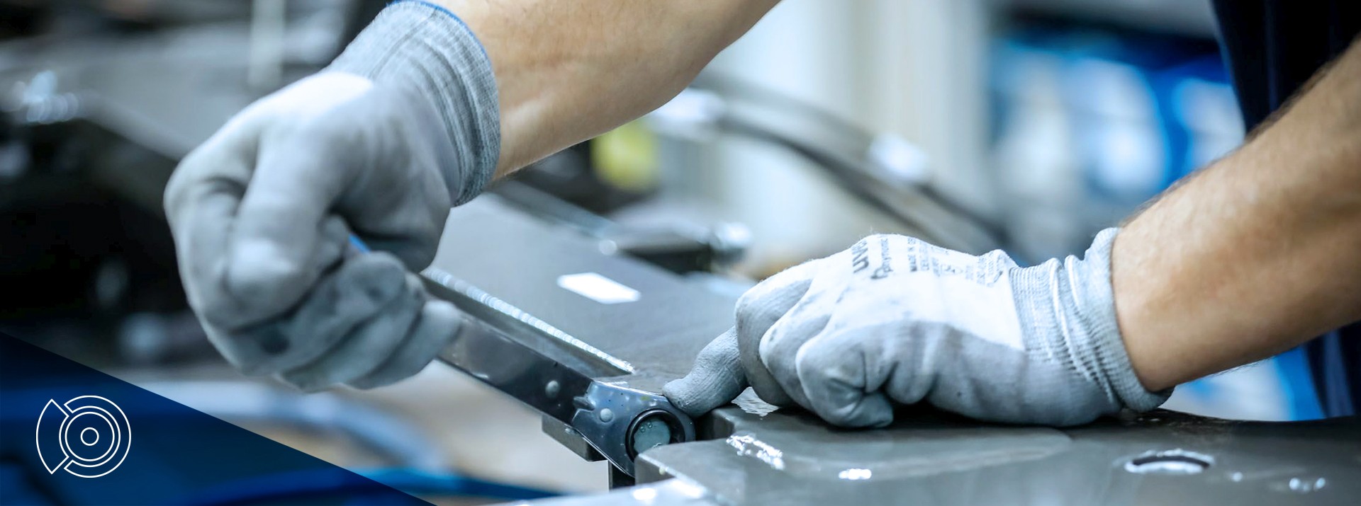 Worker using tools on metal component assembly