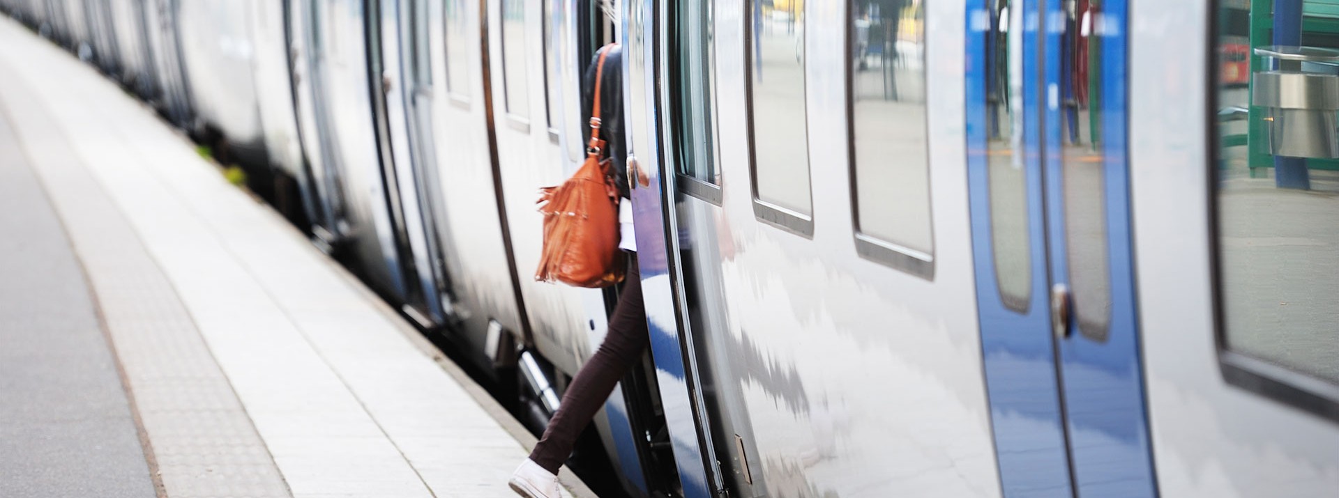 Passenger boarding train at urban station platform.