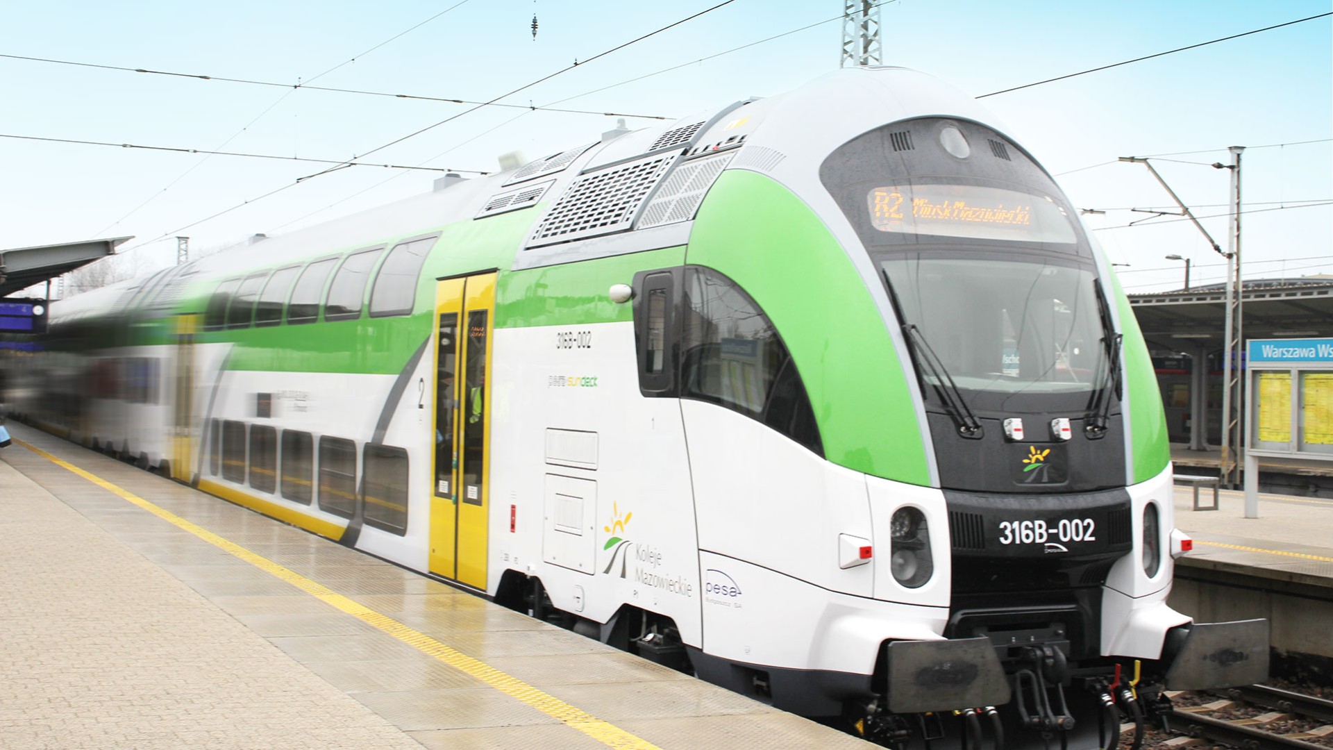 Double-decker train at a railway station platform.