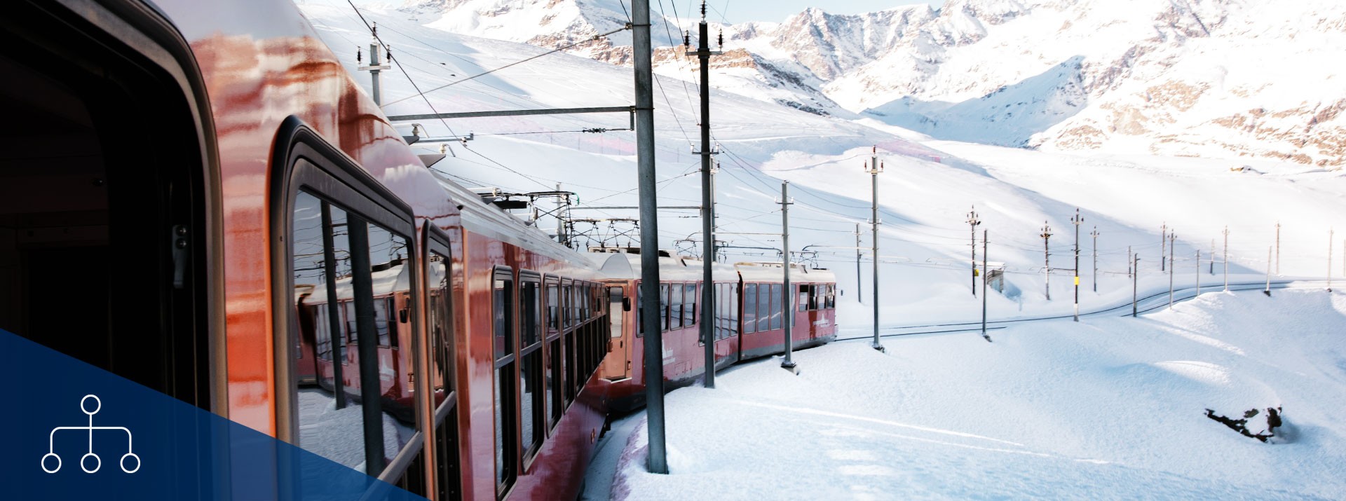 Train navigating snowy mountains in winter landscape.