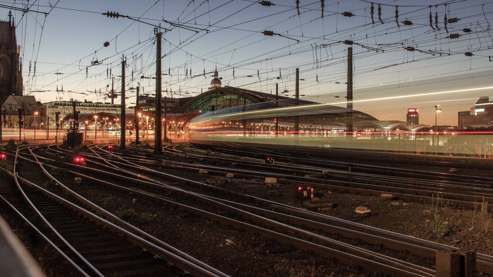 Train passing through railway tracks at dusk