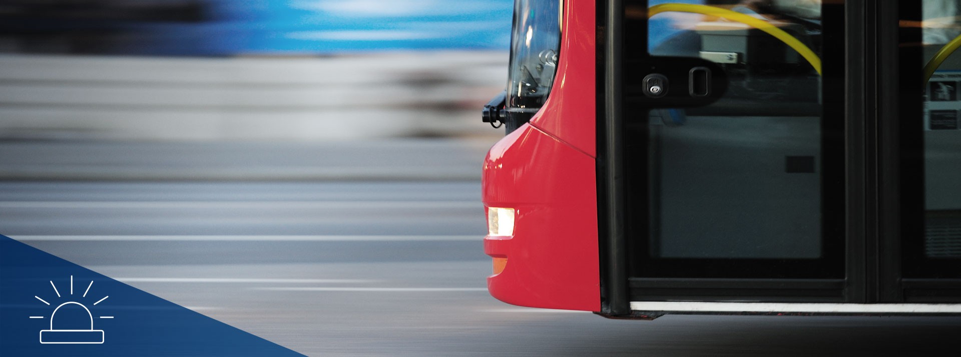 Red bus in motion on urban street.