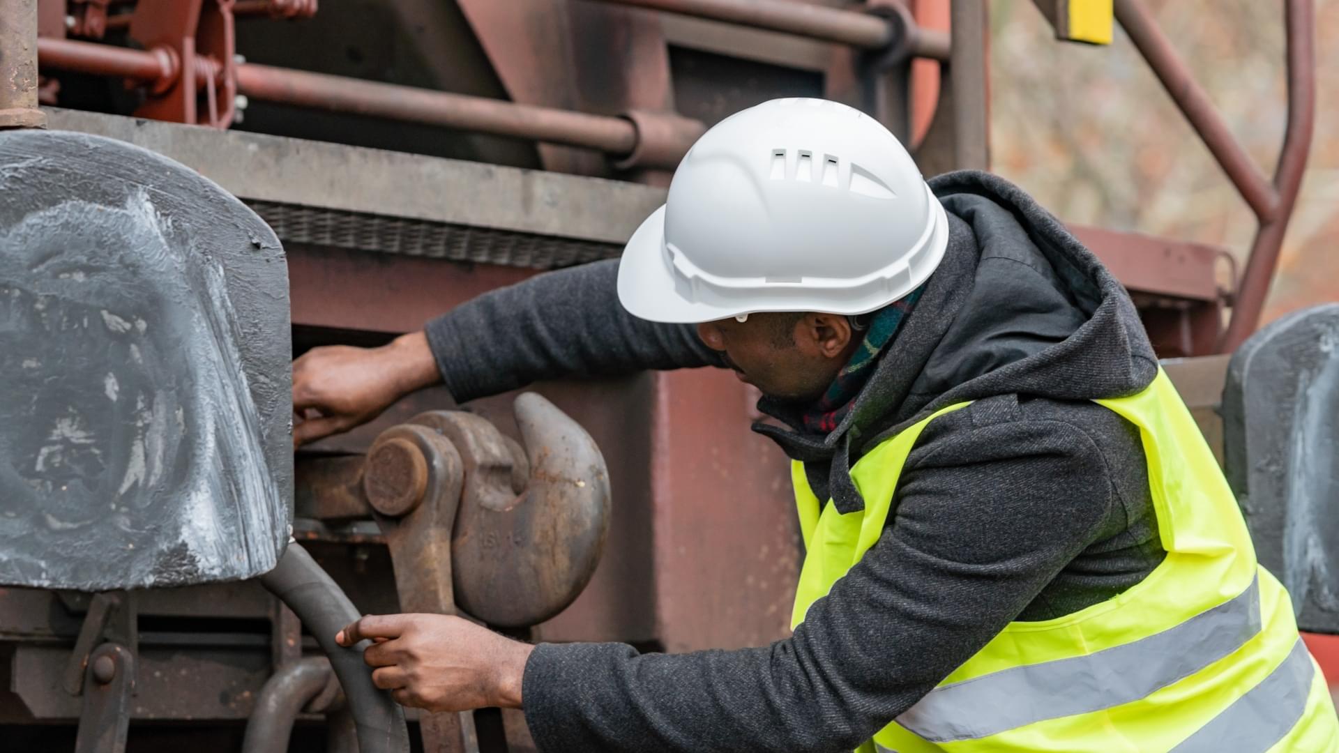 Rail worker and a manual coupler on a freight car