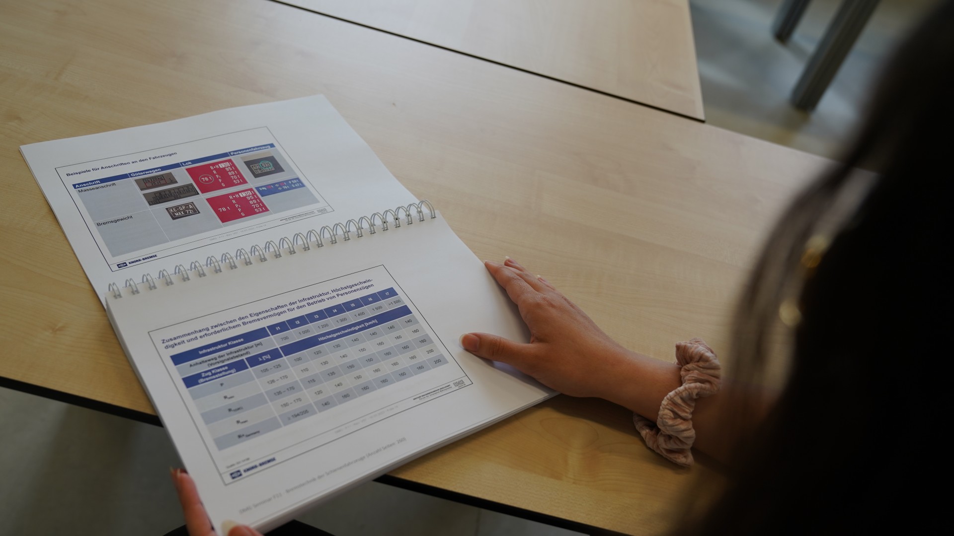 Person examining a report on a table.
