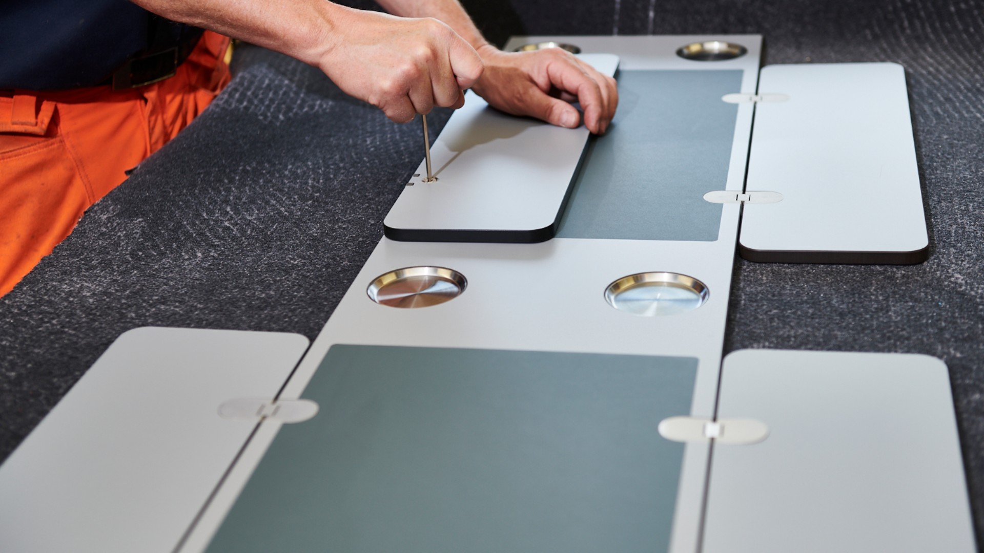 Hands assembling modular components on work surface.