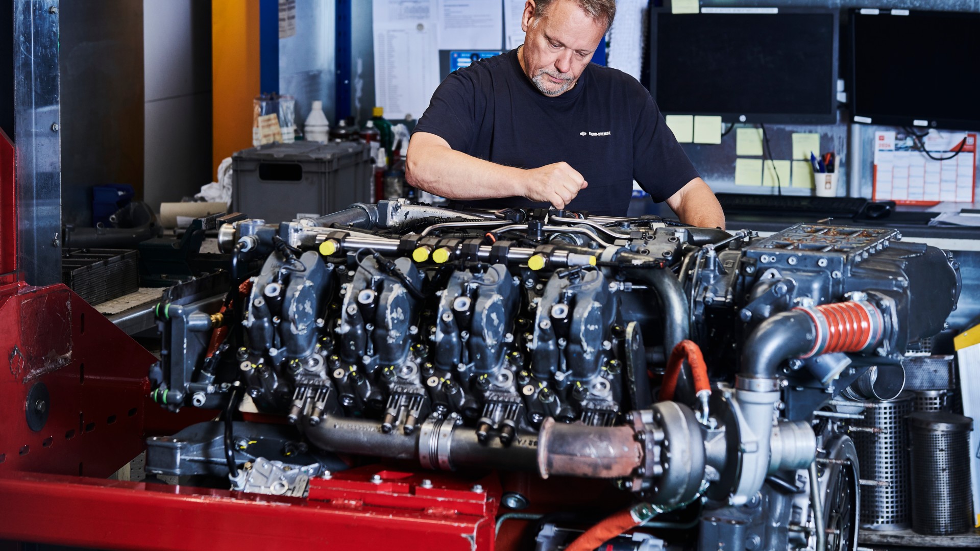 Man inspecting a large diesel engine component.