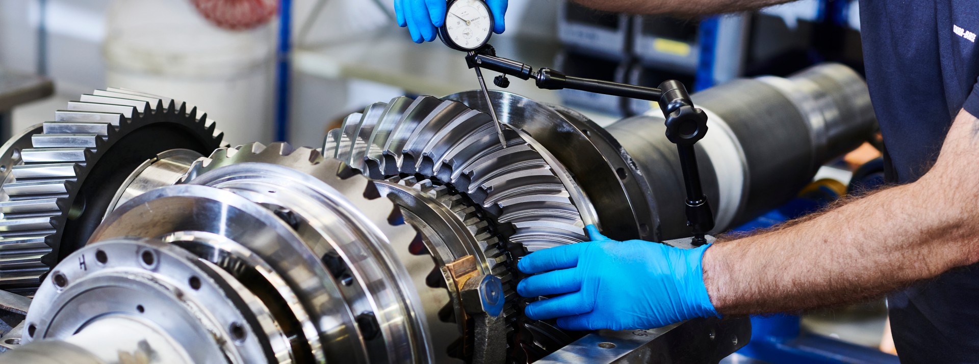Employee measuring gear components with precision tools