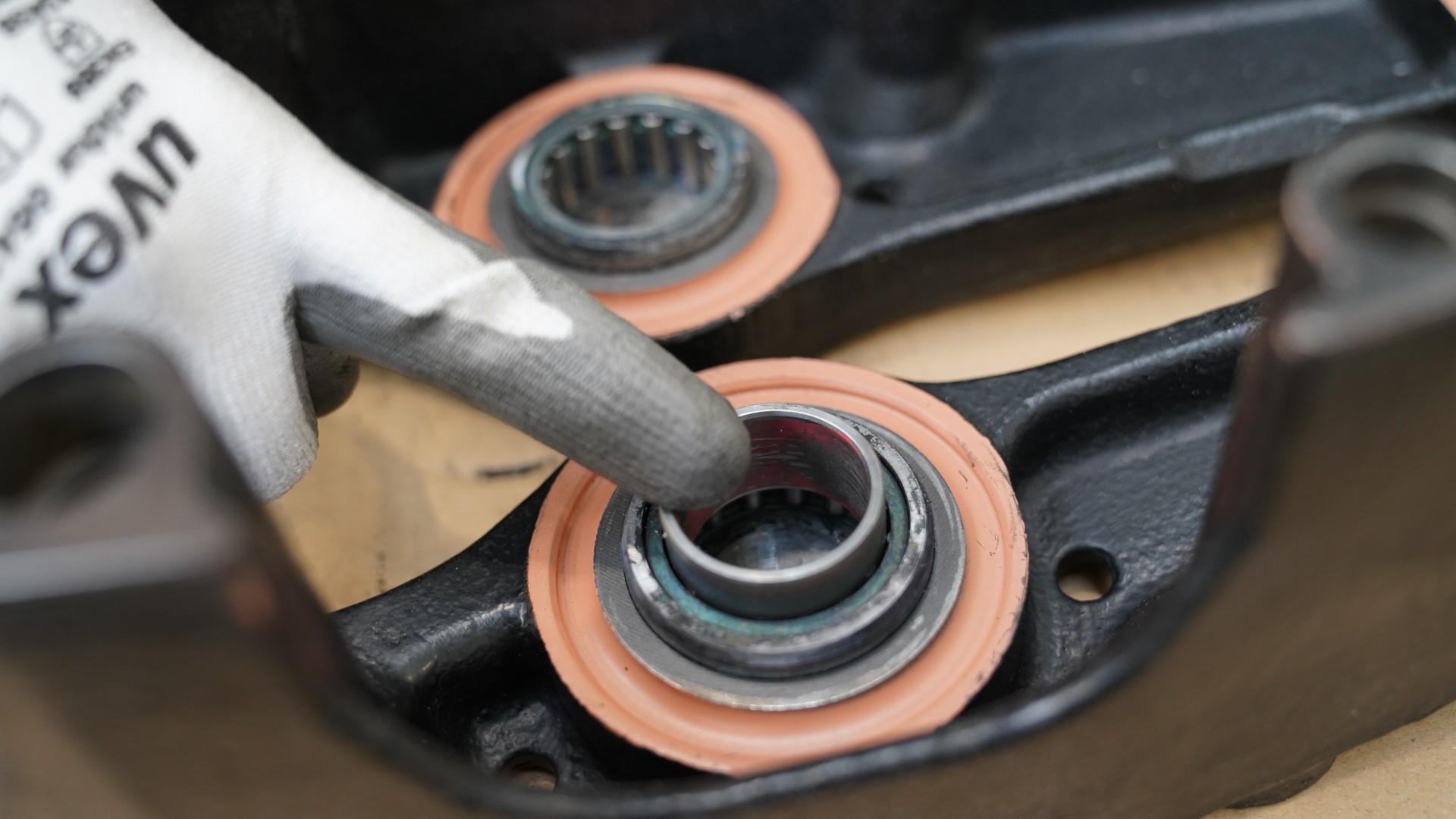Finger pressing bearing into mechanical assembly component.