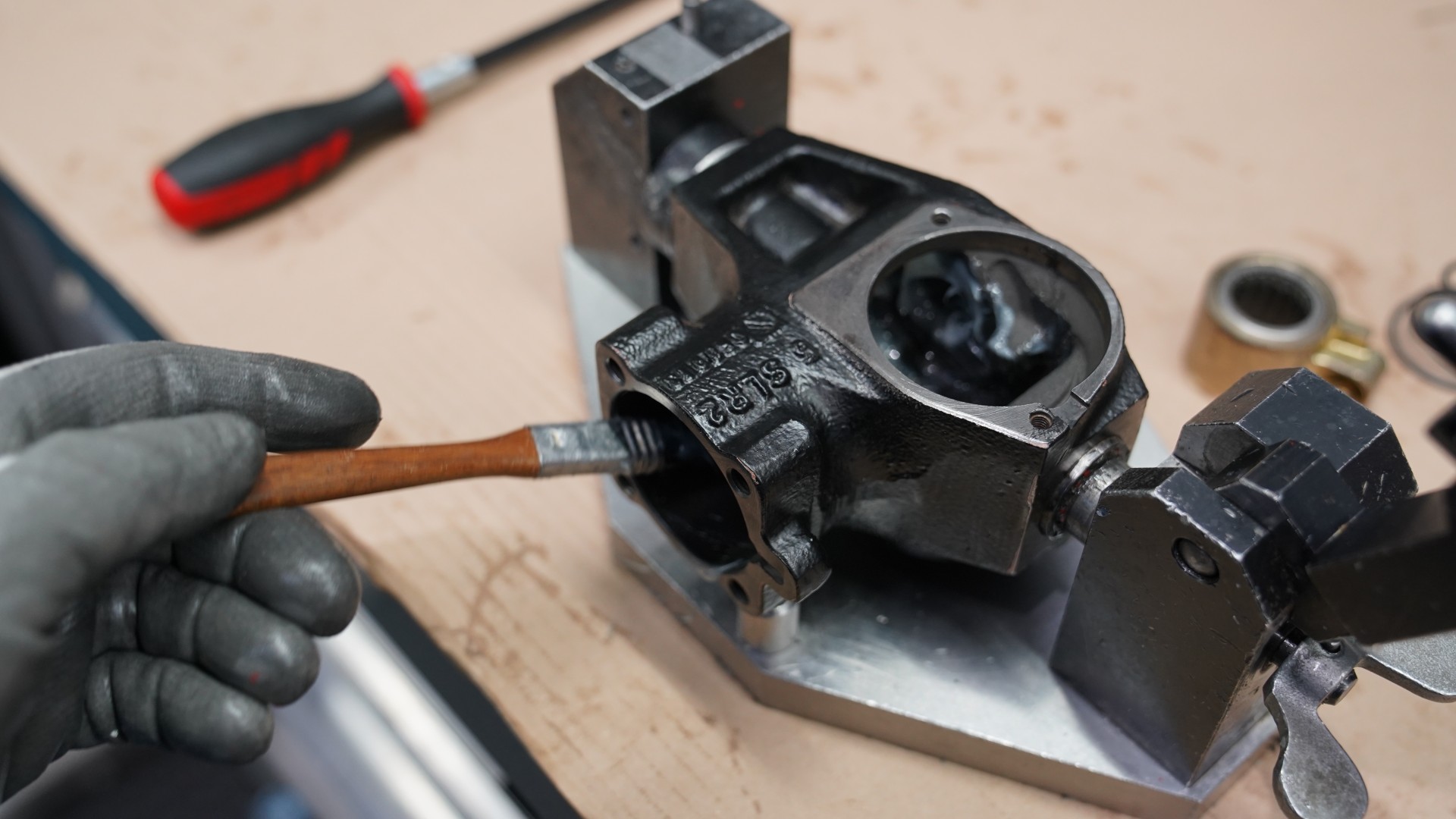 Hand applying lubricant to automotive component in