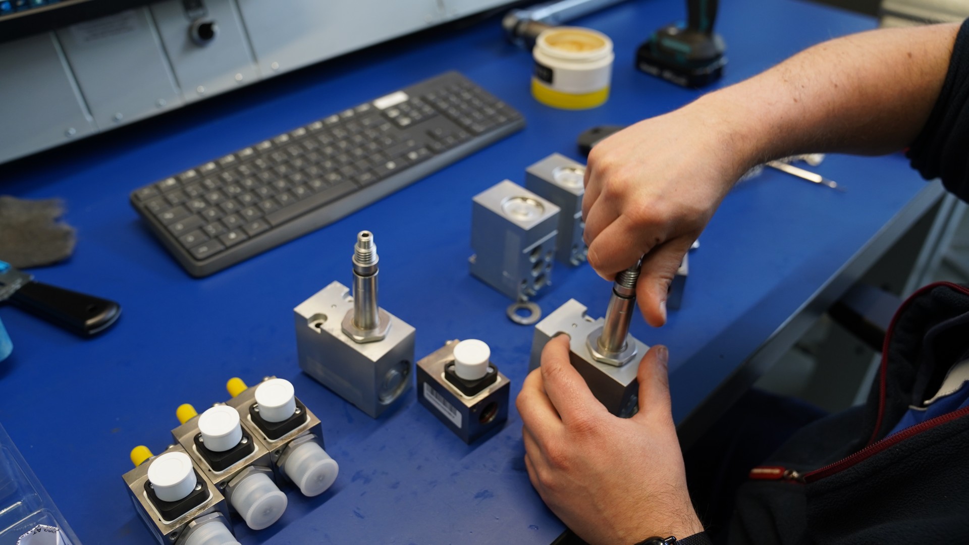 Technician assembling mechanical components on workspace