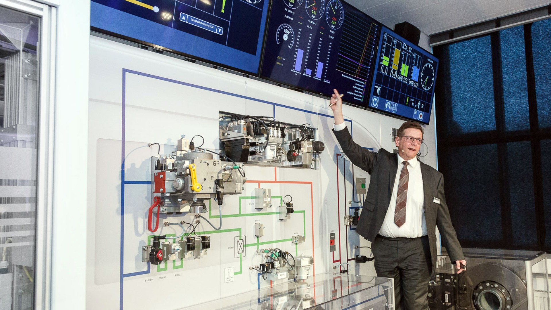 Mitarbeiter präsentiert Technologie und Diagramme an Bildschirm.