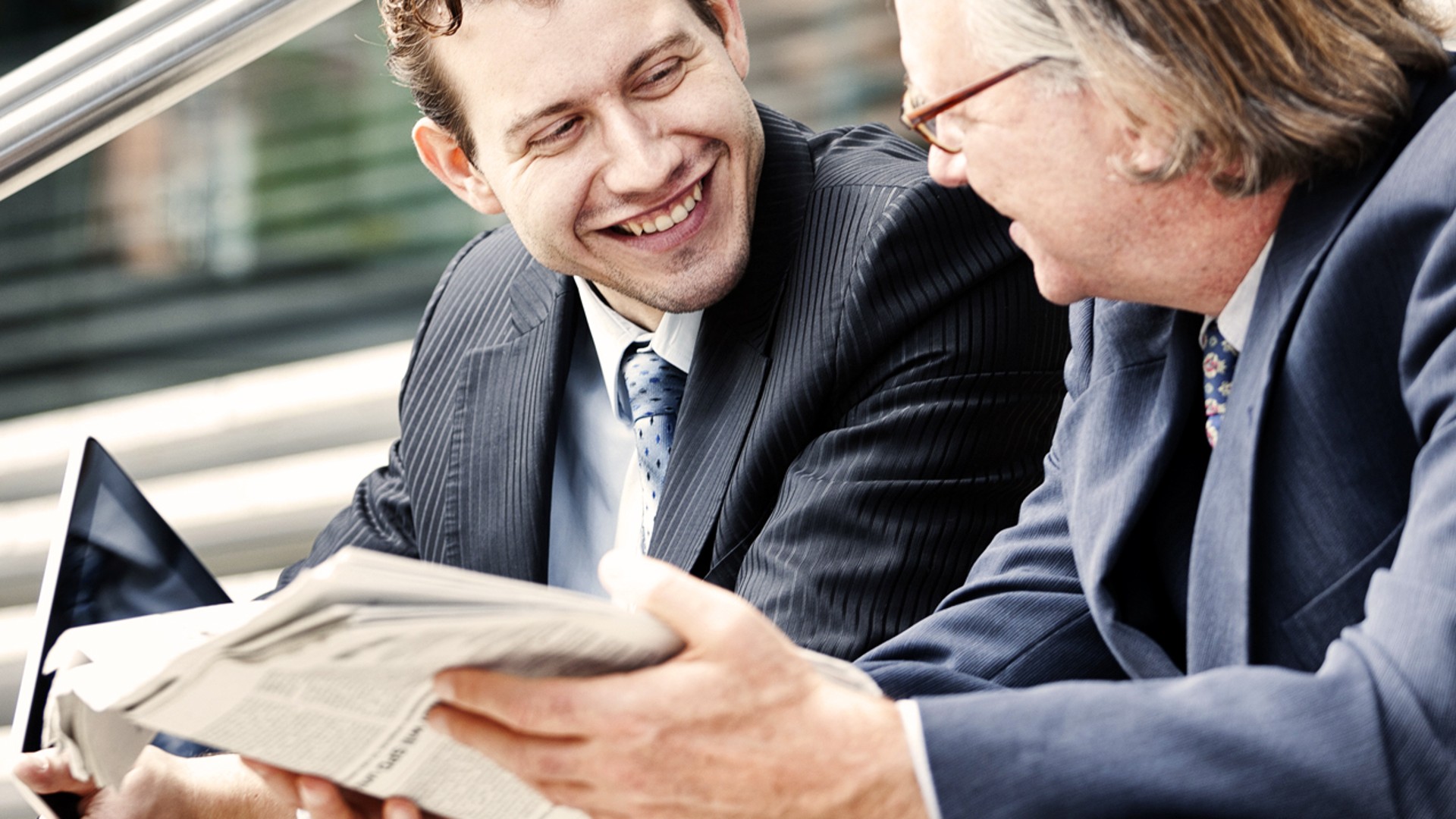 Two men in business suits discussing documents.