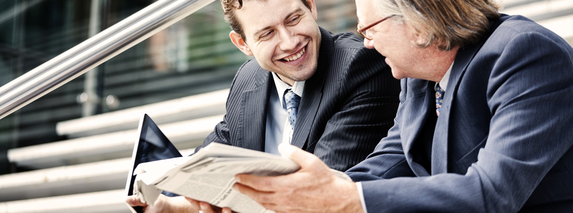 Two men in business suits discussing documents.