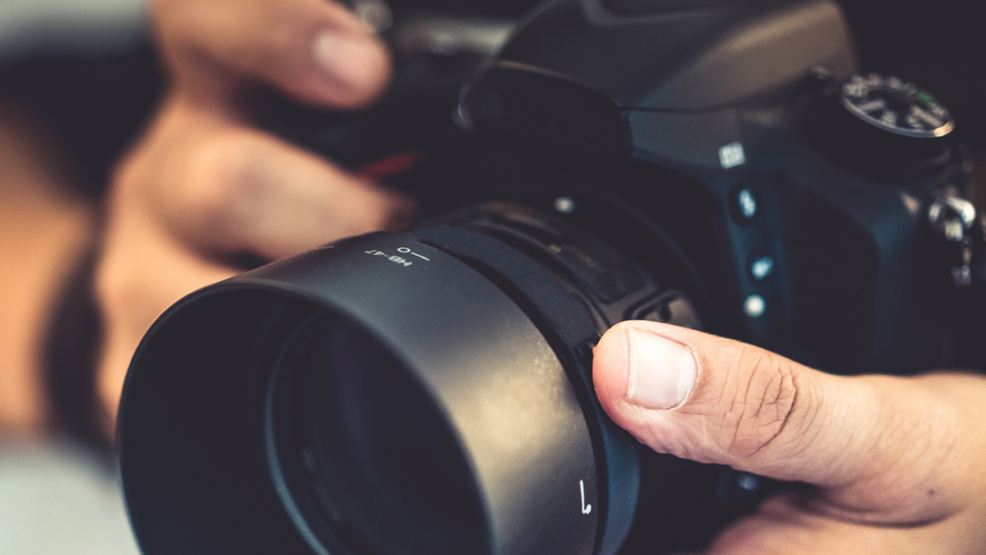 Person holding a professional DSLR camera.