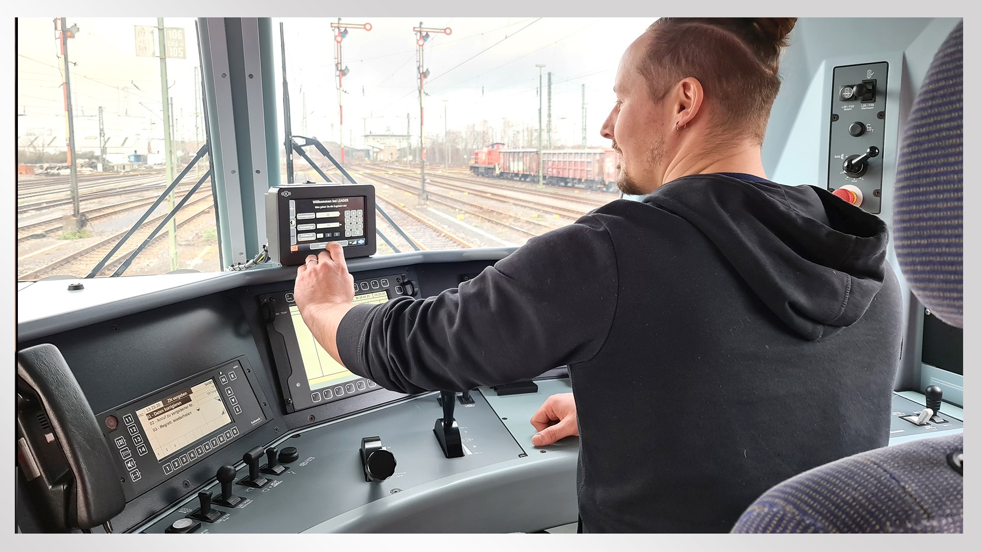 Train operator using control panel in locomotive