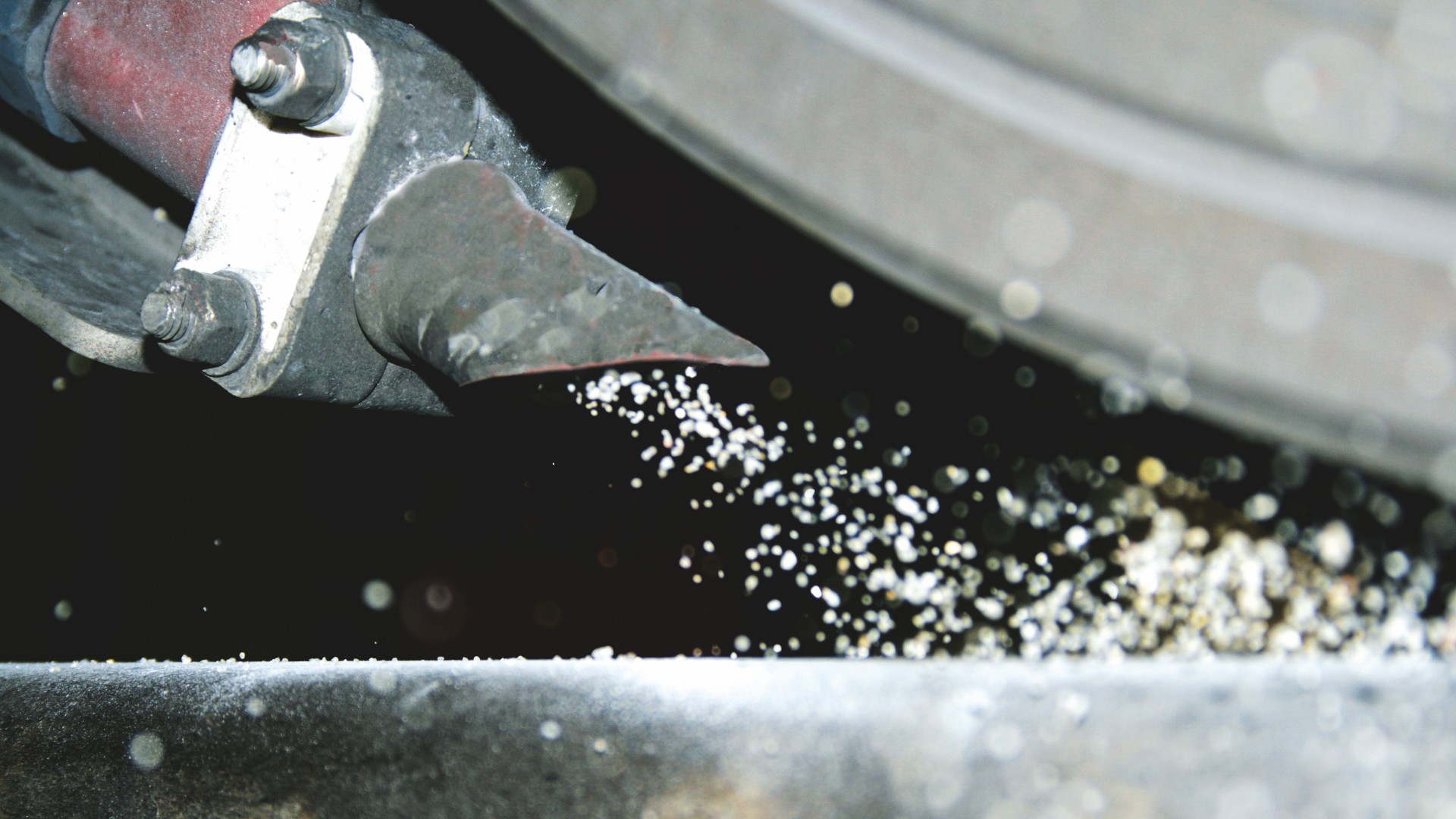 Metal cutting process with sparks and debris.