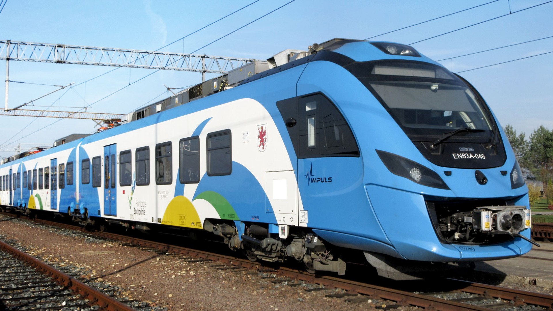 Blauer Regionalzug auf Gleisen im Bahnhof.