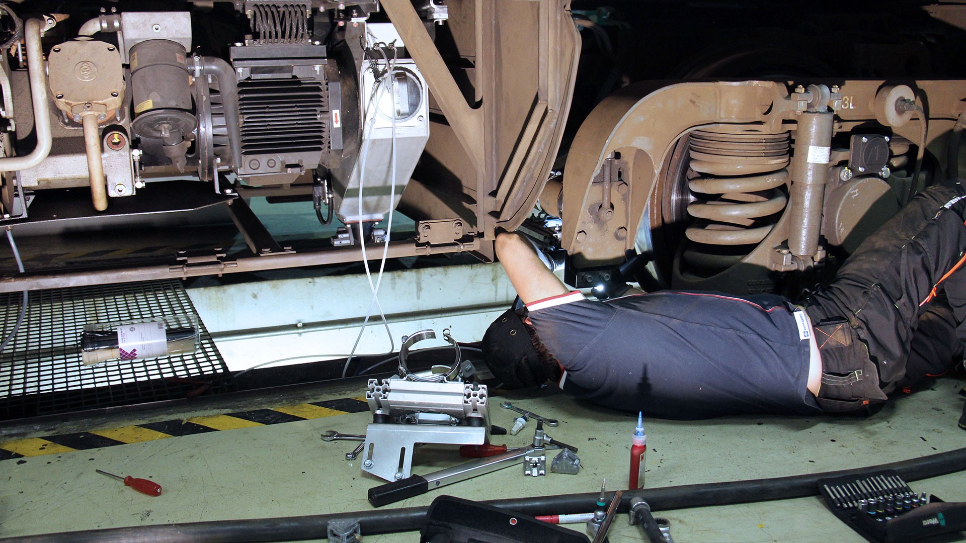 Mechanic repairing machinery under vehicle chassis