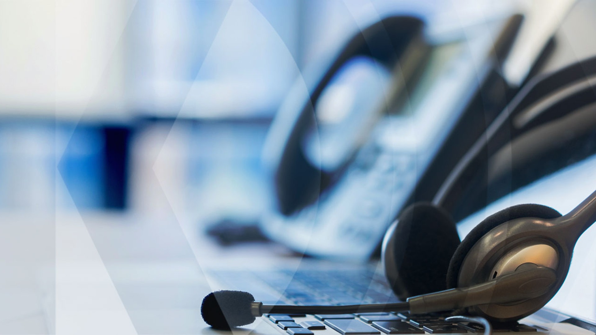 Headset on laptop with blurred office background.