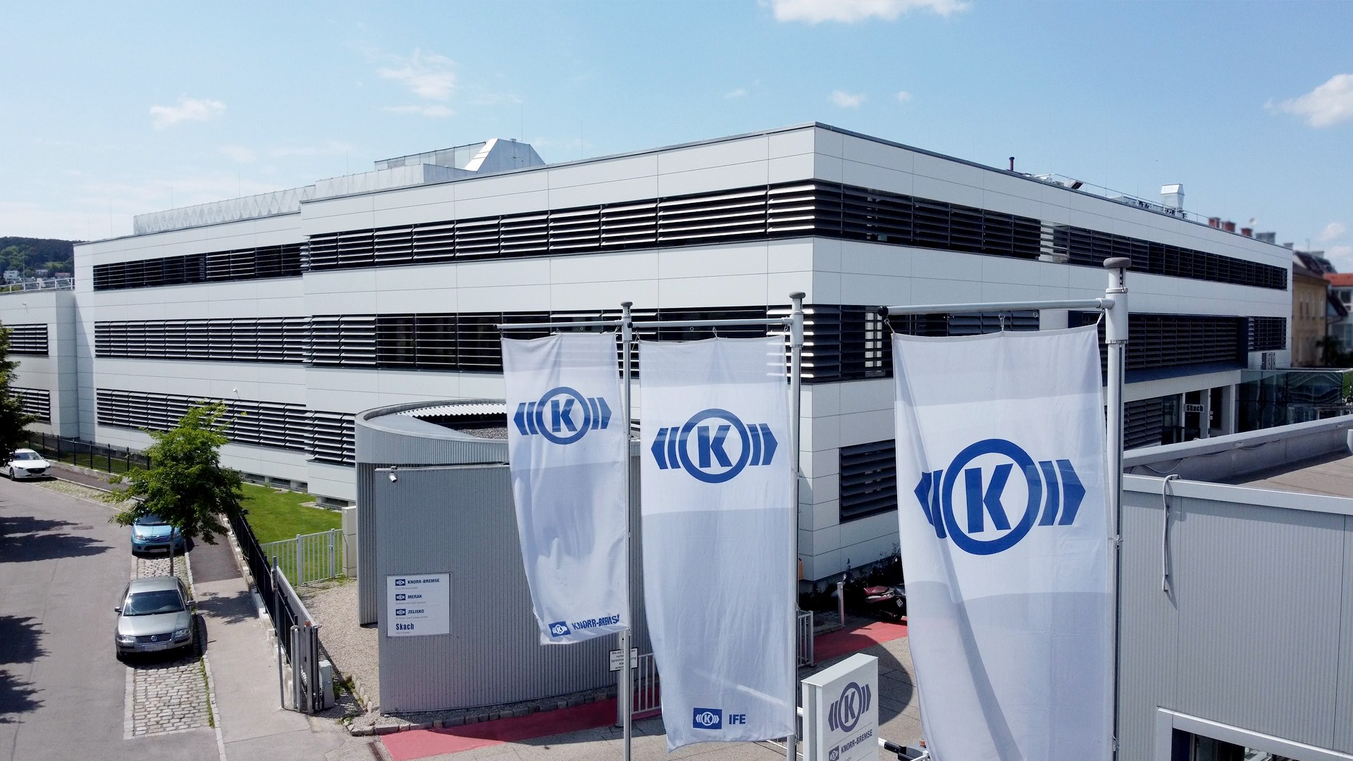 Knorr-Bremse building with branded flags and signage.