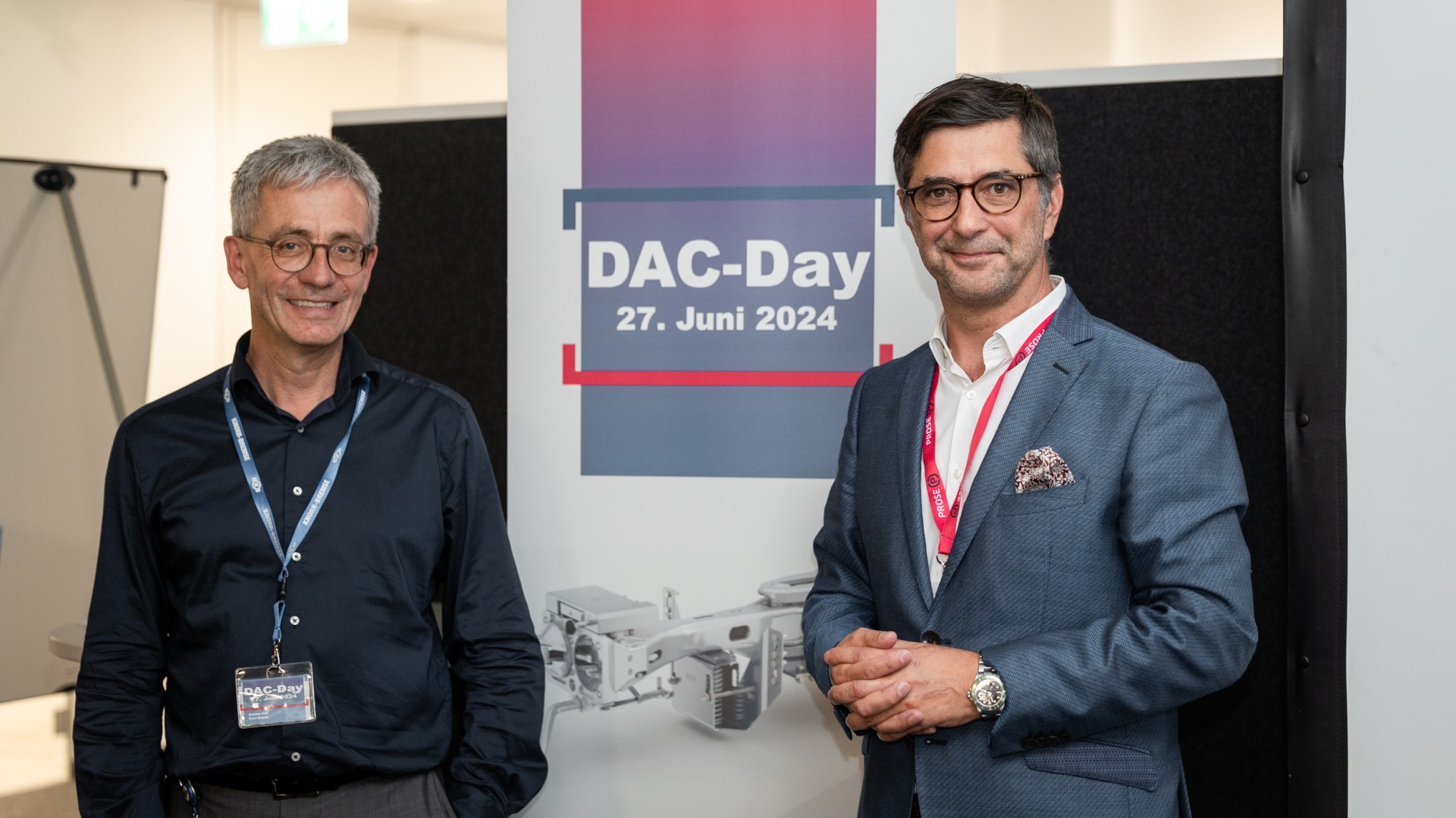 Two men at DAC-Day event poster.