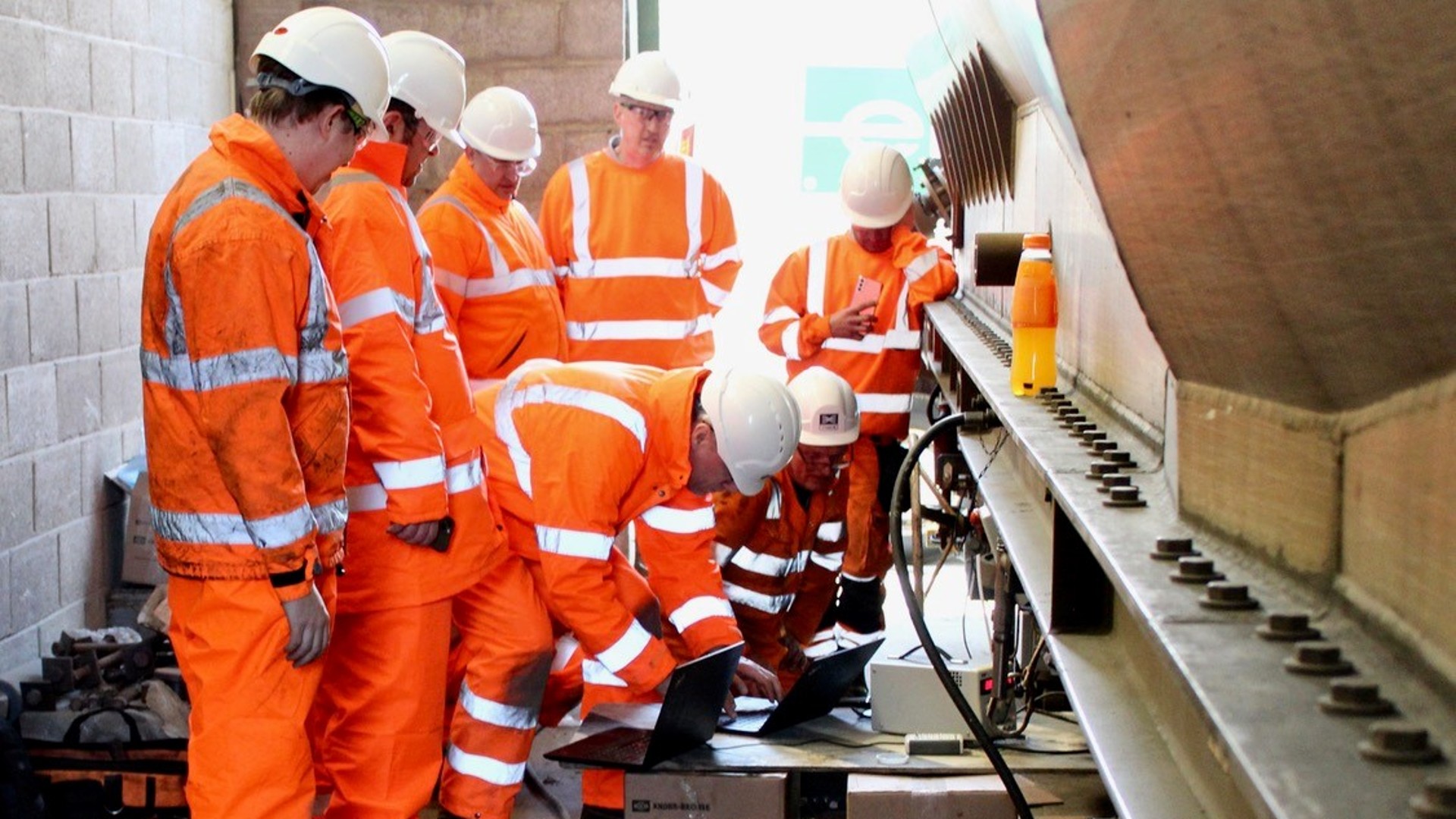 Workers next to a VTG iWagon to install the FreightControl Sentinel of Knorr-Bremse