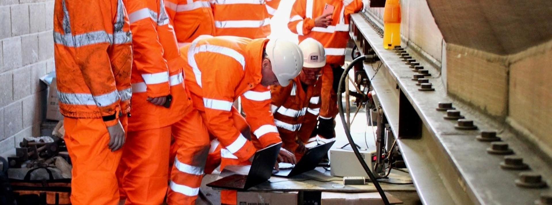 Workers next to a VTG iWagon to install the FreightControl Sentinel of Knorr-Bremse