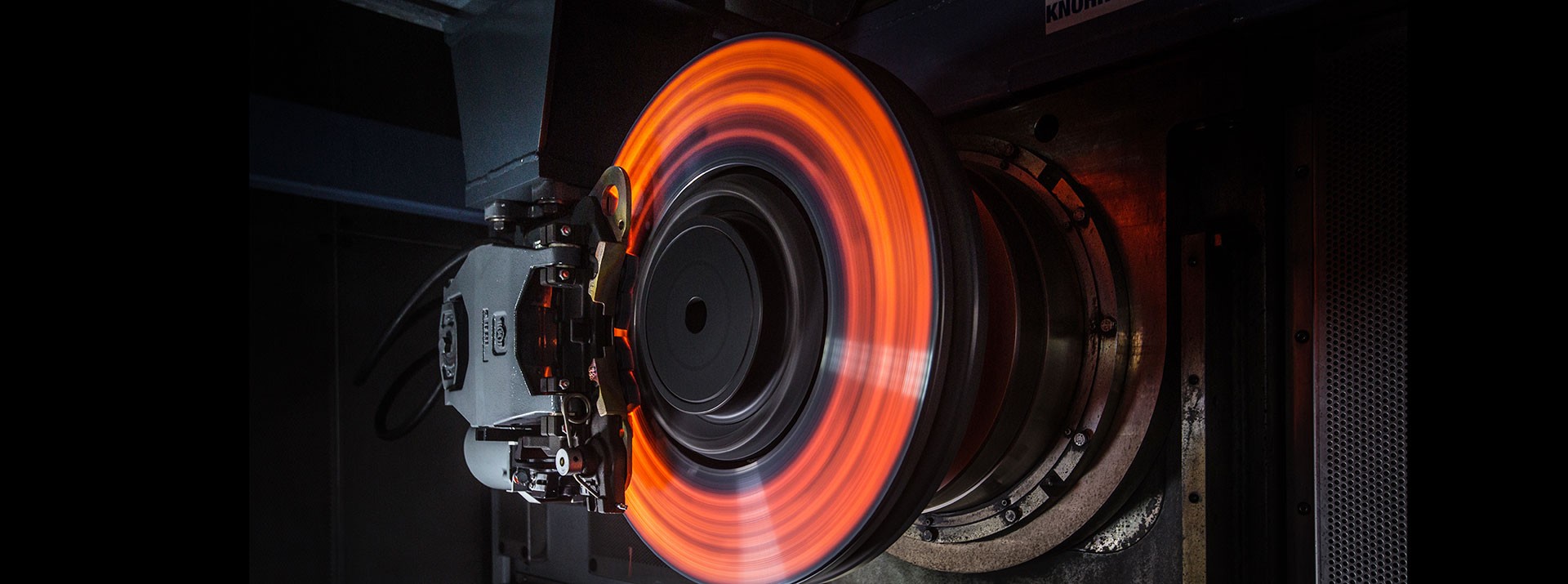 Spinning brake disc emitting orange light.