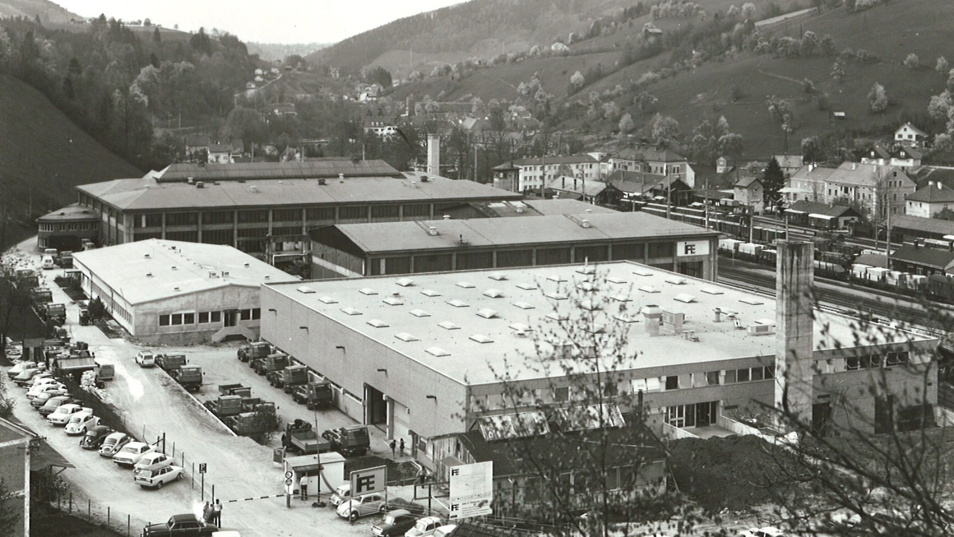 Historic industrial complex with surrounding landscape.