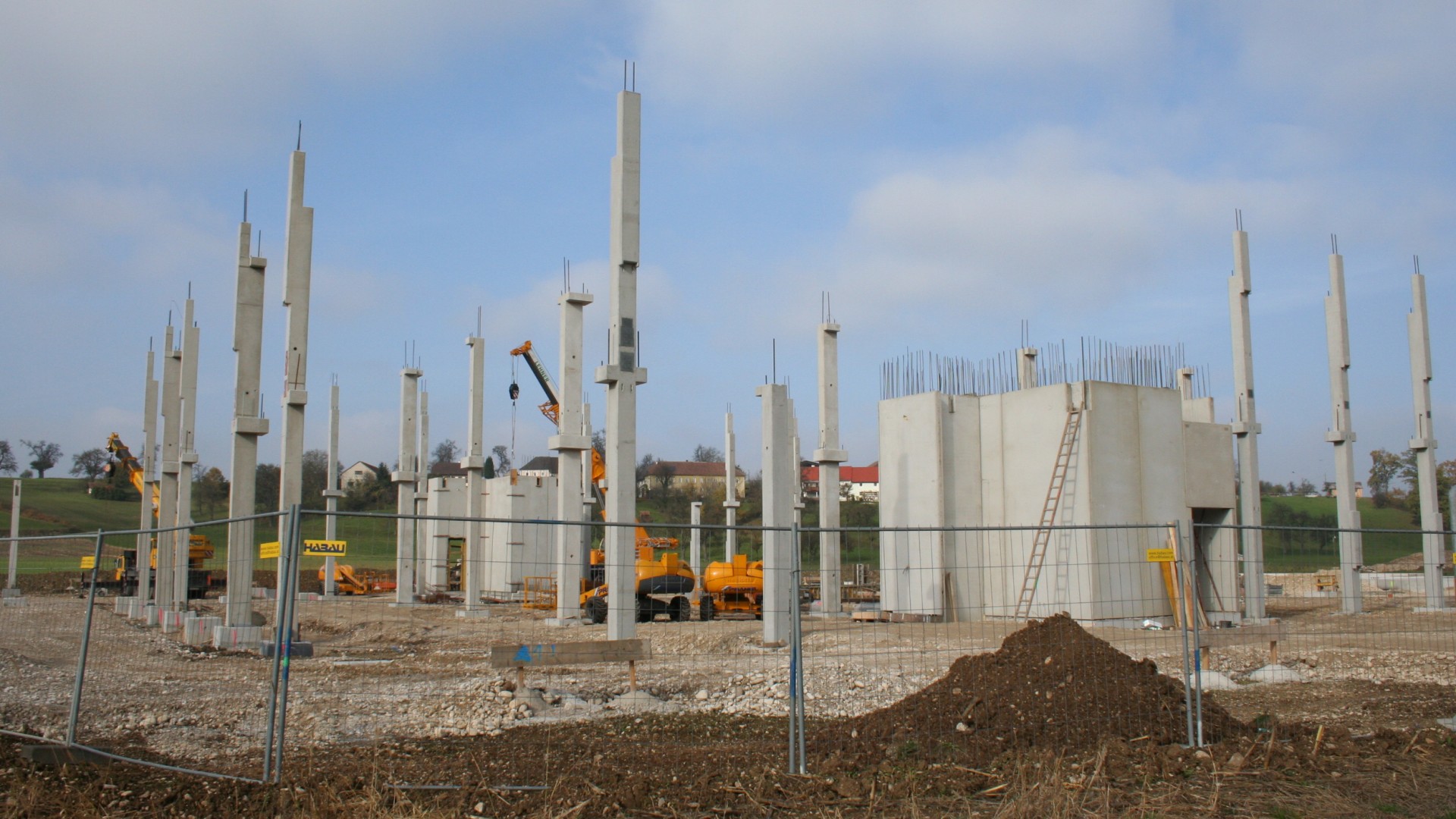 Construction site with concrete pillars and machinery.