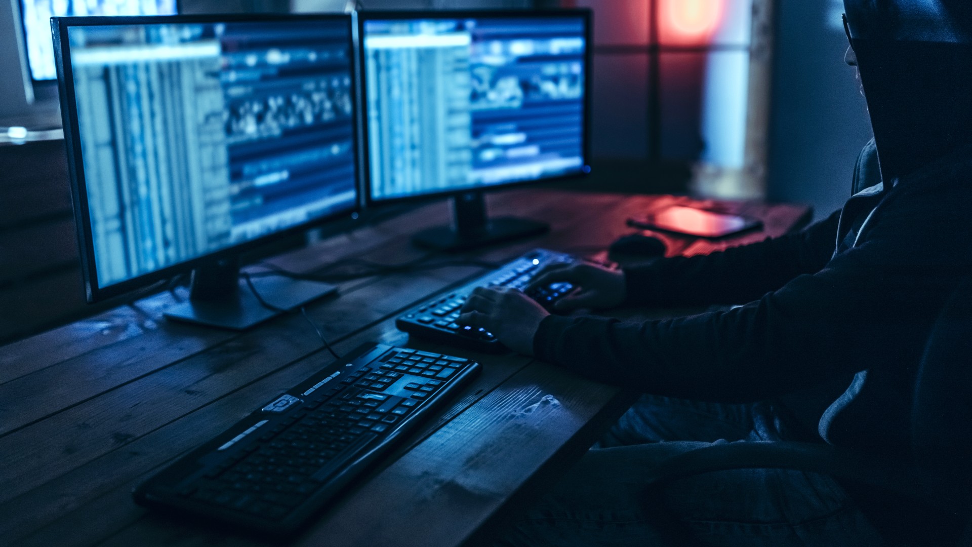 Hacker infront of two computer