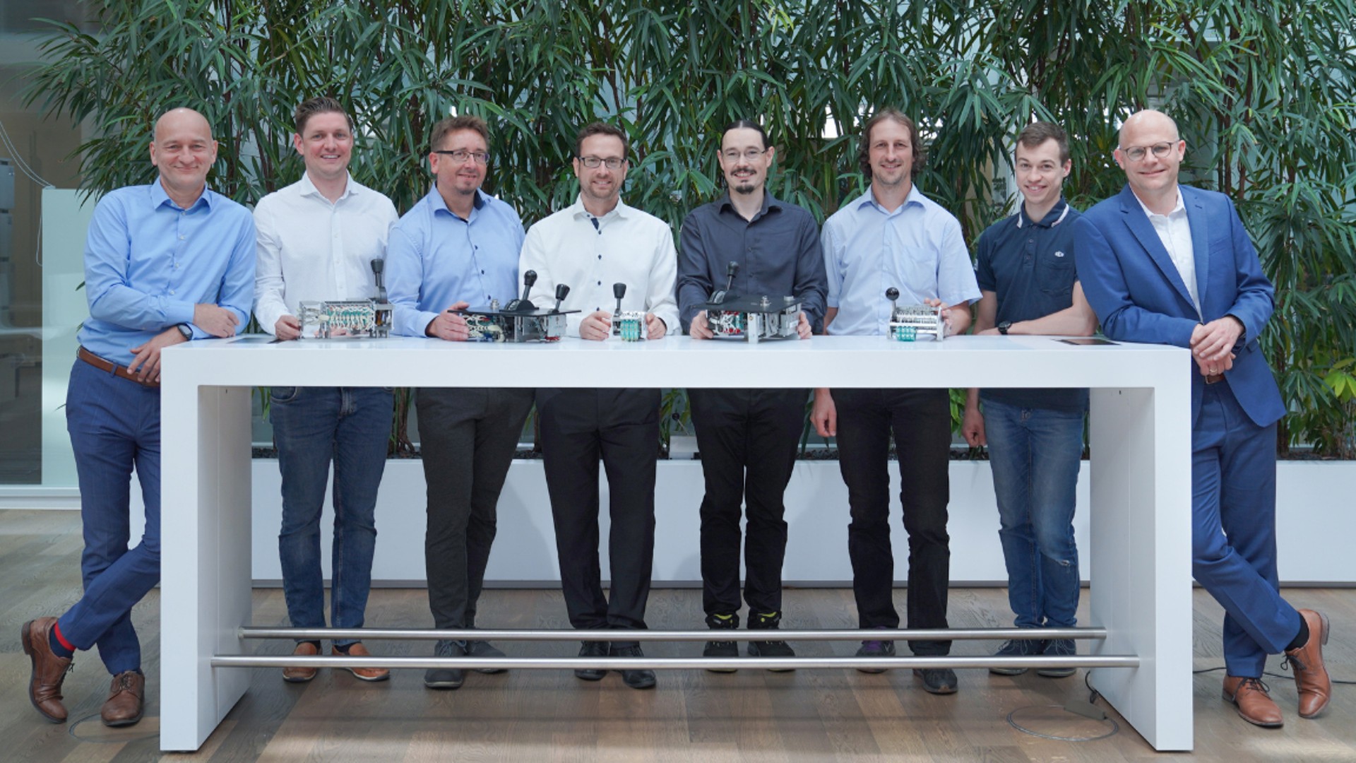 Group of professionals standing by technology models.