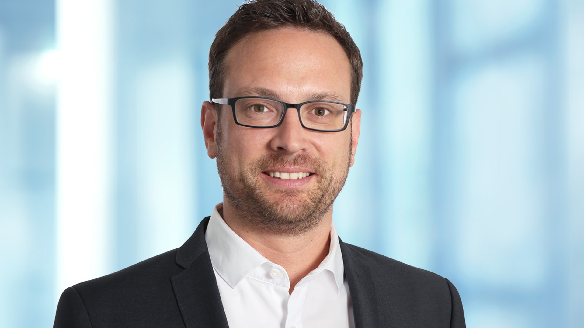 Business professional with glasses smiling confidently