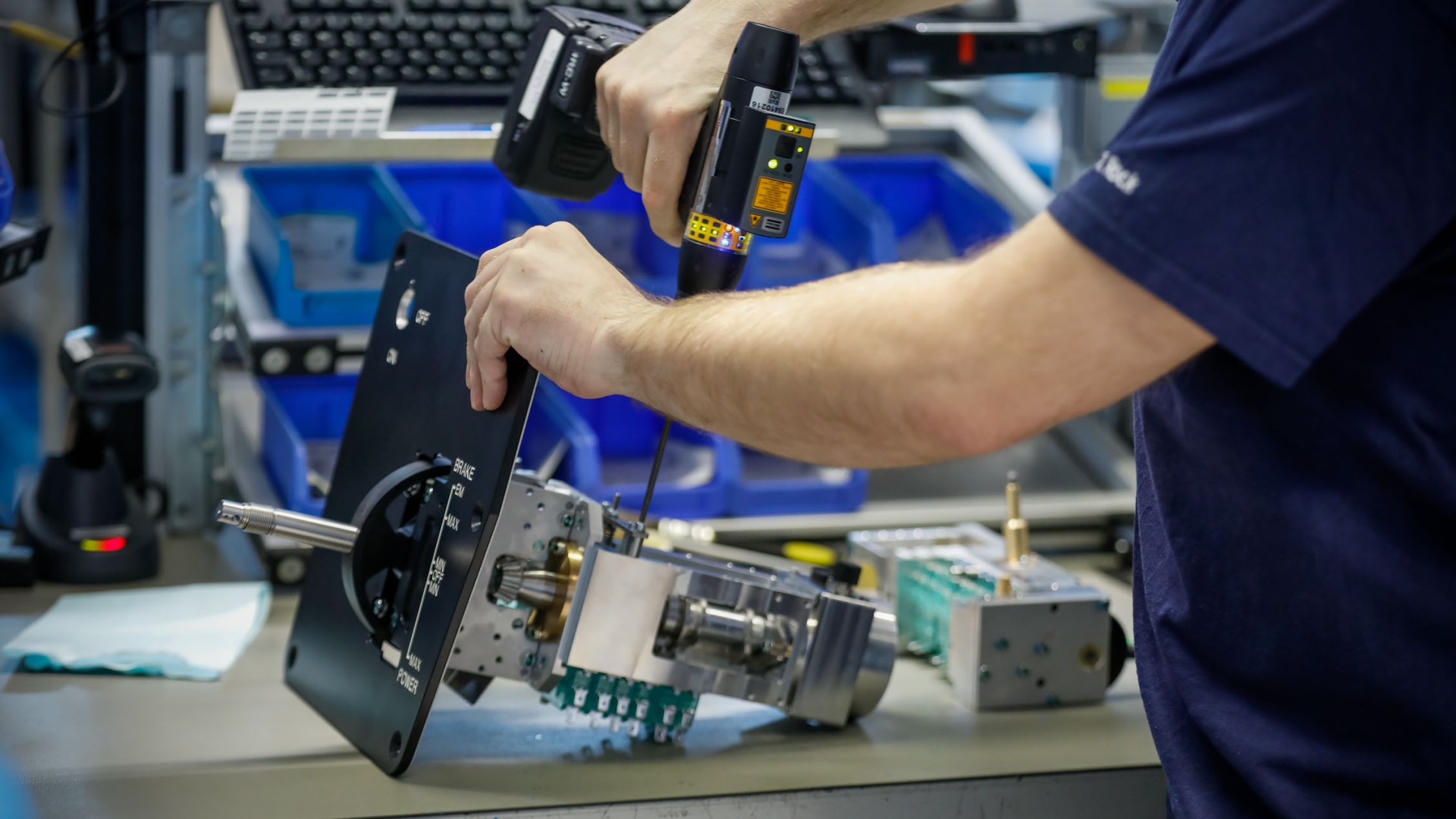 Technician assembling mechanical components with tools.