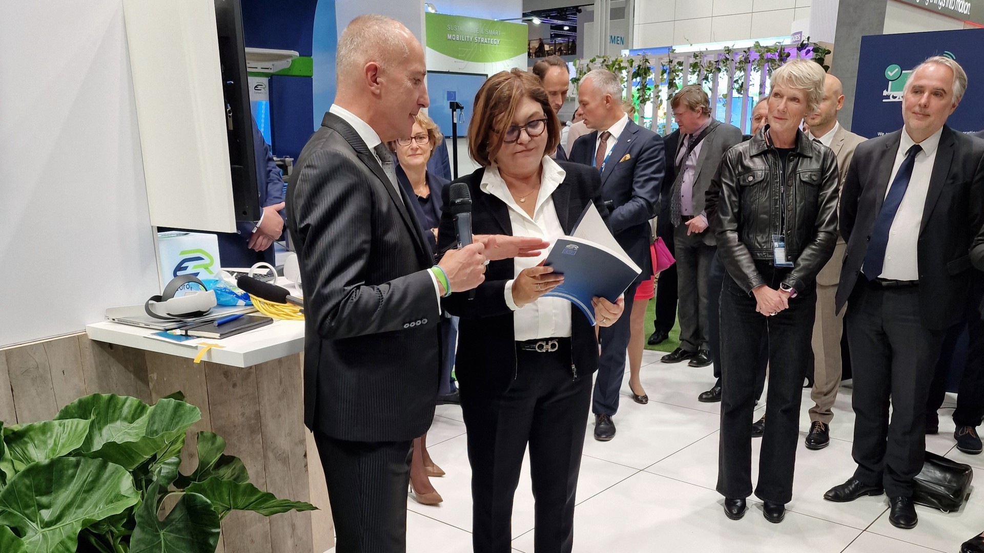 Mitarbeiter diskutieren am Messestand, Gruppenansicht.