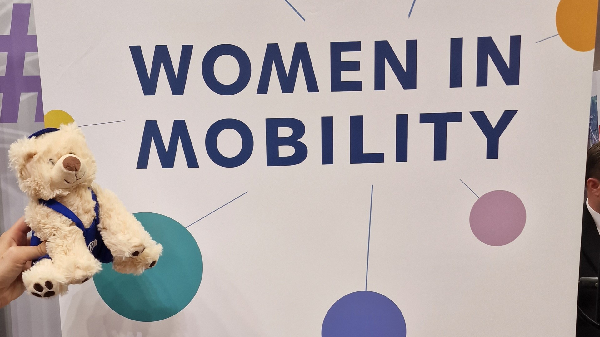 Bärchen vor Banner "Women in Mobility" anzeigen.