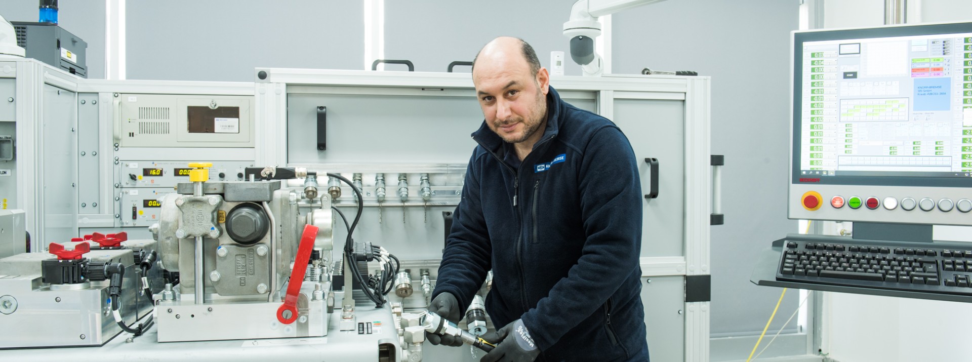 Employee assembling machinery in a technical workspace.