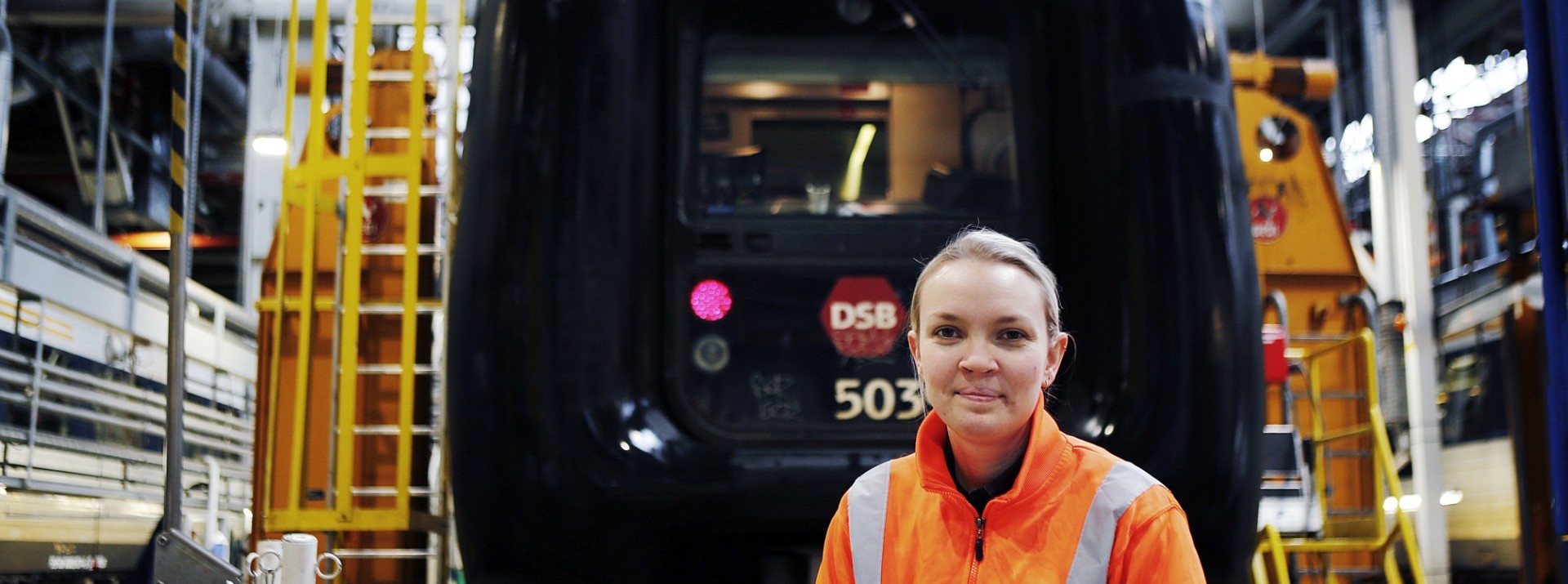 Woman in safety gear at train facility