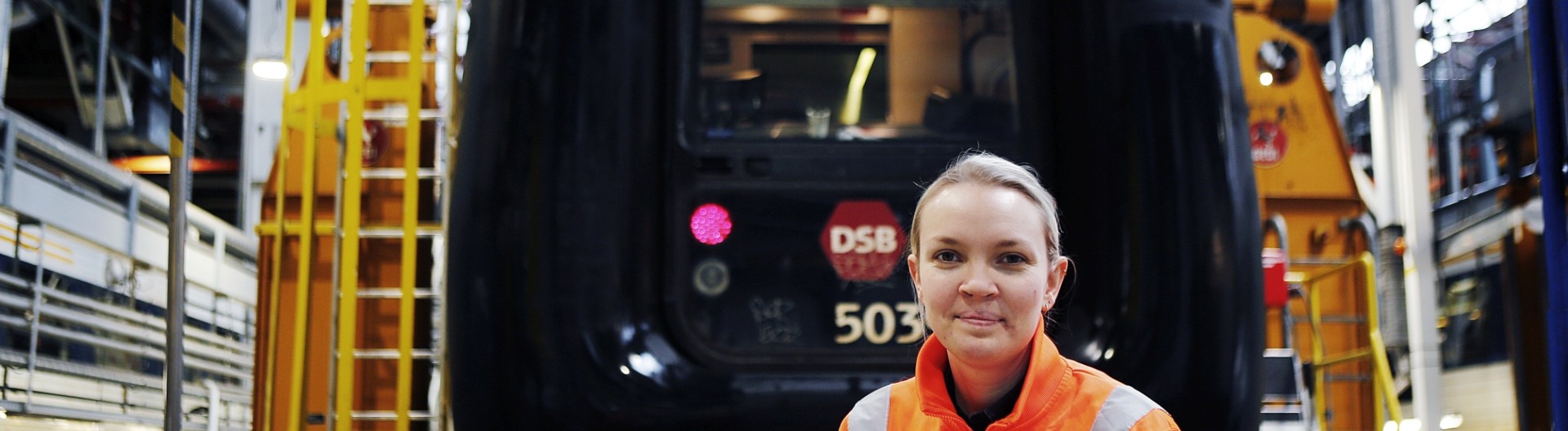 Woman in safety gear at train facility