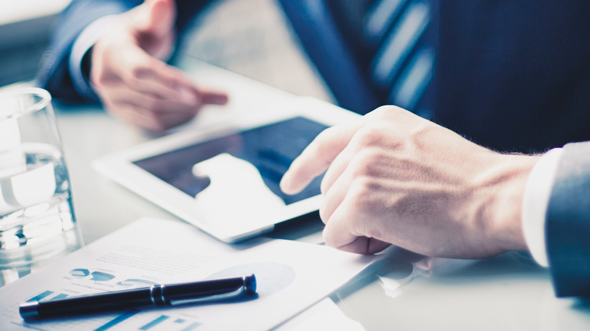 Business meeting with documents and tablet device.