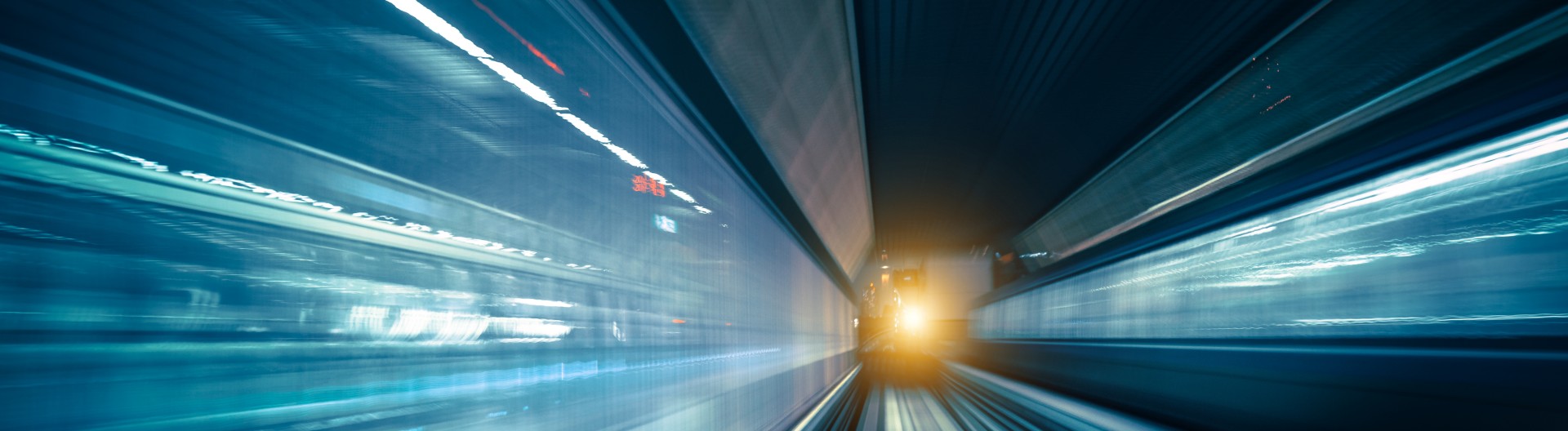 Schnell fahrender Zug in heller Tunnelumgebung.