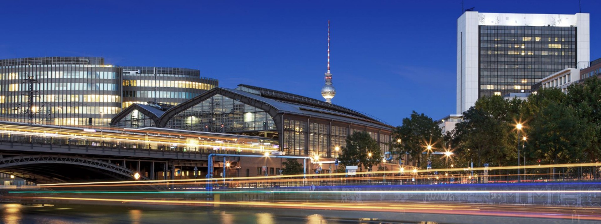 Berlin cityscape with river and illuminated buildings.