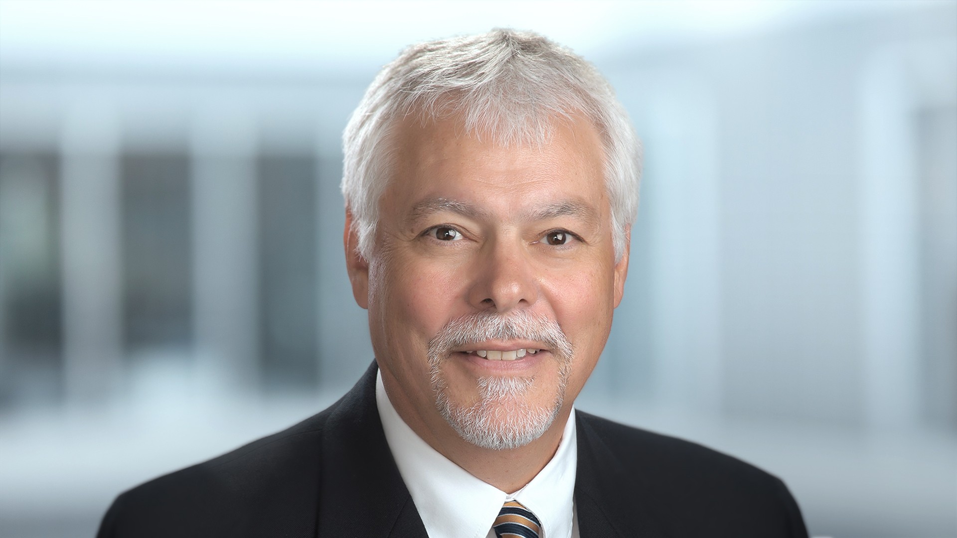 Professional man with gray hair and suit.