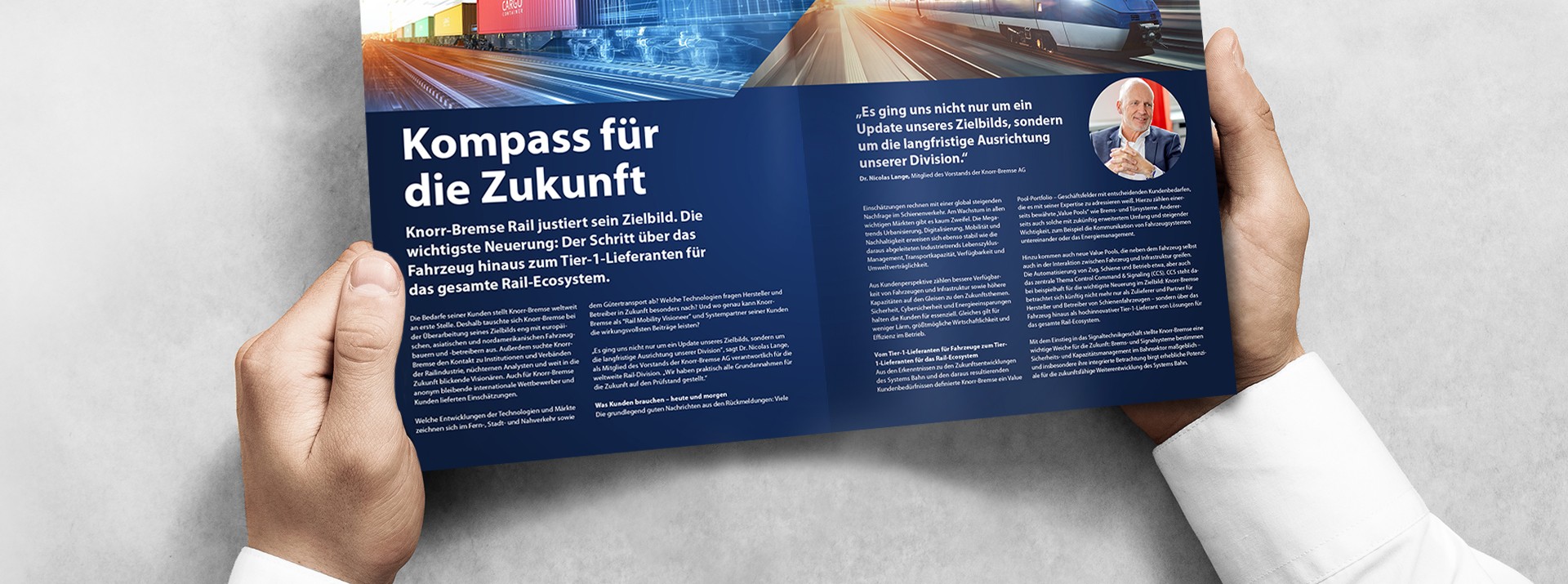 Zwei Hände halten den informer und die Seite "Kompass für die Zukunft" ist zu sehen.