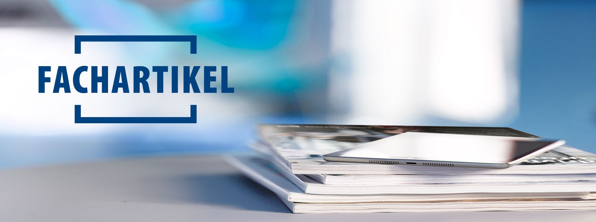 Stapel von Zeitschriften und einem Tablet-PC.