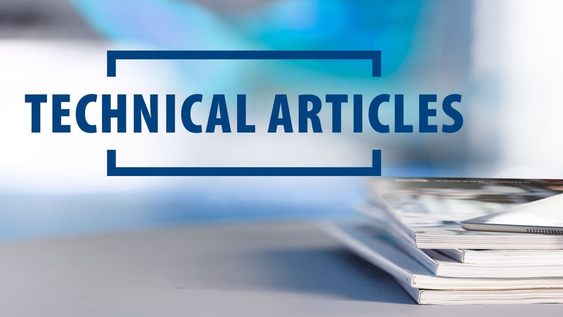 Technical articles stacked beside a tablet device.